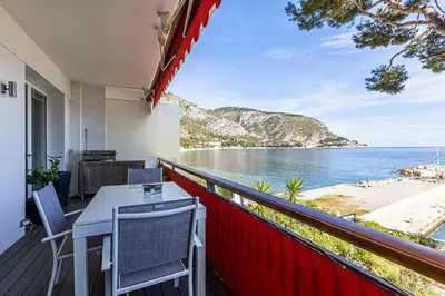 a balcony with a table and chairs and the ocean at Appartement Eze bord de mer in Èze
