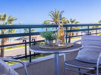 a table with a bottle of wine and a plant on a balcony at Studio La Joconde by Interhome in Nice