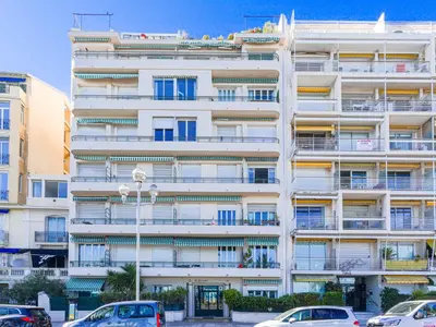 a white building with cars parked in front of it at Studio La Joconde by Interhome in Nice