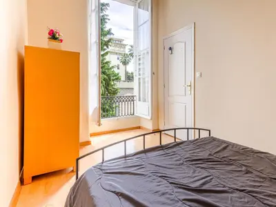 a bedroom with a bed and a large window at Apartment Le Masséna by Interhome in Nice