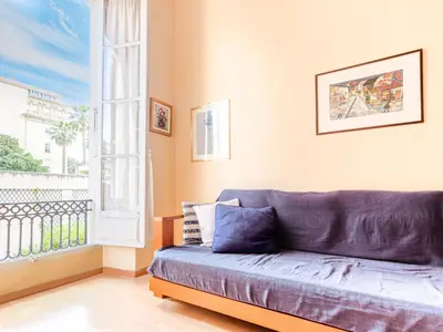 a blue couch in a room with a window at Apartment Le Masséna by Interhome in Nice