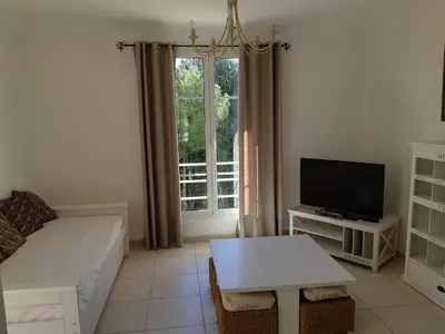 a living room with a couch and a tv and a table at Les Bastides D'Hélène in Èze