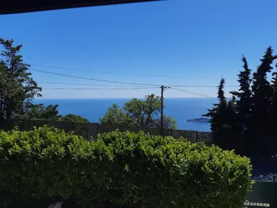 a view of the ocean from behind a hedge at Les Bastides D'Hélène in Èze
