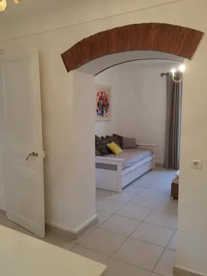 a living room with a bed and an open door at Les Bastides D'Hélène in Èze