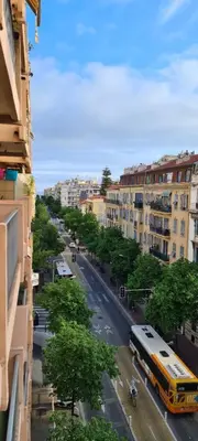 a school bus driving down a city street with buildings at Centre de Nice - Musiciens - Maréchal - Balcon 500m Promenade des Anglais in Nice