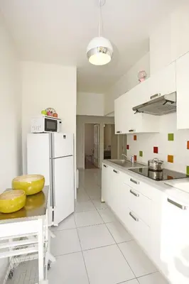 a kitchen with white cabinets and a white refrigerator at AIGUE-MARINE - Superbe appartement Vue Mer 4 personnes au Port de Nice in Nice