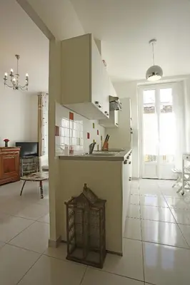 a kitchen with white cabinets and a white tile floor at AIGUE-MARINE - Superbe appartement Vue Mer 4 personnes au Port de Nice in Nice