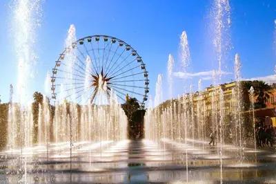a ferris wheel in front of a water fountain at Plein centre Appartement climatisé et spacieux avec grande terrasse sur le toit à Nice in Nice