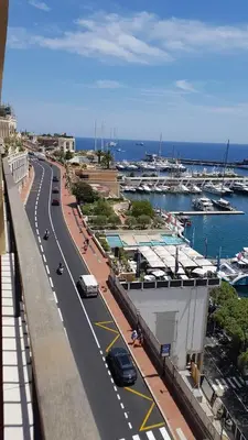 a road with cars parked on it next to a marina at Plein centre Appartement climatisé et spacieux avec grande terrasse sur le toit à Nice in Nice