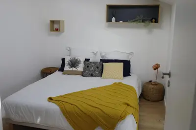 a bedroom with a white bed with a yellow blanket on it at Luxueux 3 Pièces - Wilson in Nice