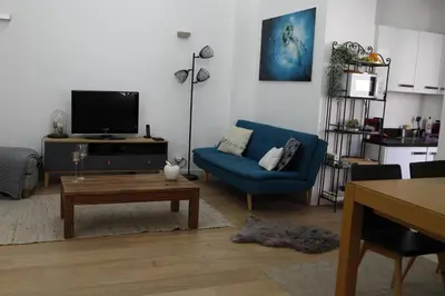 a living room with a blue couch and a tv at Luxueux 3 Pièces - Wilson in Nice