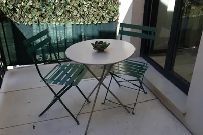 a white table and two chairs on a balcony at Luxueux 3 Pièces - Wilson in Nice