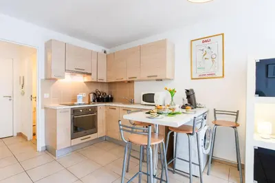 a kitchen with a table and chairs in a room at VICTOR HUGO AP4159 Nice, by Riviera Holiday Homes in Nice