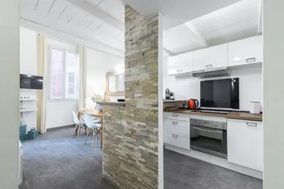 a kitchen with white cabinets and a brick wall at Duplex in Rue de la Préfecture Old Town 2 Bdrs in Nice