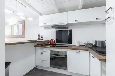a kitchen with white cabinets and a black appliance at Duplex in Rue de la Préfecture Old Town 2 Bdrs in Nice