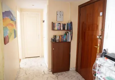 a hallway with a door and a book shelf with books at Chill Out Apartment, 2 mins from beach in Nice