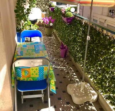 a table and a chair and an umbrella on a balcony at Chill Out Apartment, 2 mins from beach in Nice