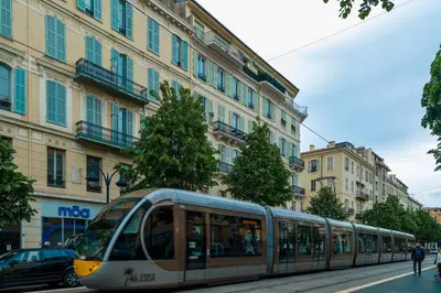 a tram on a city street with buildings at Nice Jean Médecin in Nice