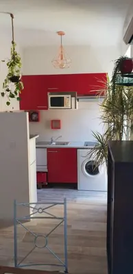 a kitchen with red and white cabinets and a dishwasher at Studio Lou Nidou, Nice Centre in Nice