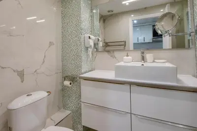 a white bathroom with a sink and a toilet at BEACH FLAT in Nice