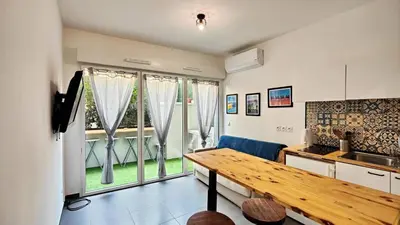 a kitchen with a wooden table and a large window at Alex Nice Studio in Nice