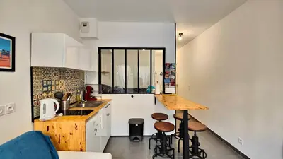 a kitchen with a counter and stools in a room at Alex Nice Studio in Nice