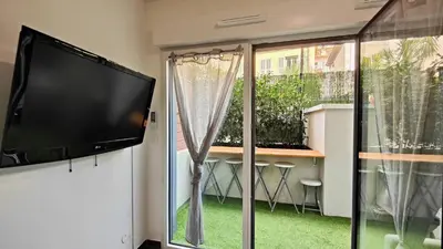 a flat screen tv hanging on a wall next to a window at Alex Nice Studio in Nice