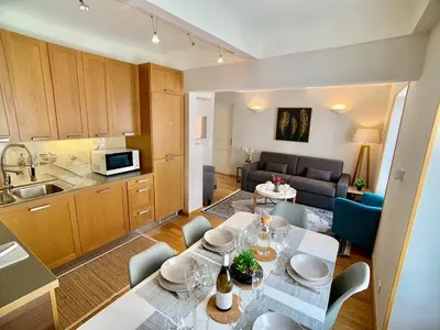 a kitchen and a living room with a table and chairs at Palais Massena - Easy Home Booking in Nice