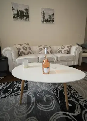 a living room with a white table with a bottle of wine at Prestige Designer Apartment, Super Central in Nice