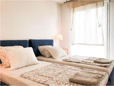 two beds in a room with a window at Domes Seaside Résidence Piscine, Free Parking, Airport Tramway in Nice