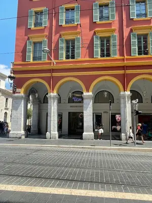 a building on a street with people walking in front of it at Cosy Cocoon Place Massena in Nice