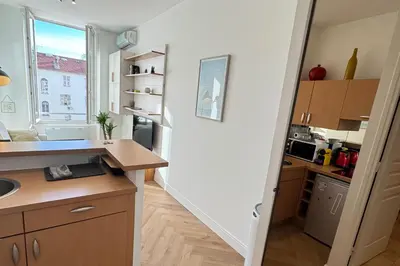 a kitchen with a stairway leading into a kitchen with a window at Cosy Cocoon Place Massena in Nice