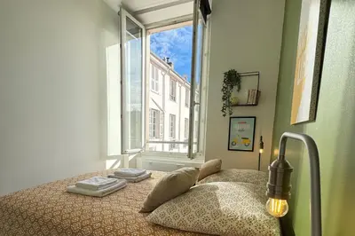 a bedroom with a bed with a window at Cosy Cocoon Place Massena in Nice