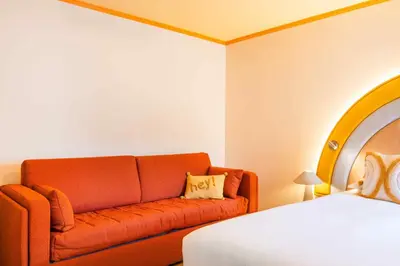 a hotel room with a couch and a bed at Nice Pam Hotel in Nice