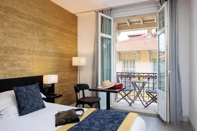 a hotel room with a bed and a balcony at Best Western Plus Hôtel Massena Nice in Nice
