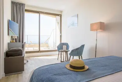 a bedroom with a bed with a hat on it at Les Terrasses d'Eze - Hôtel & Spa in Èze