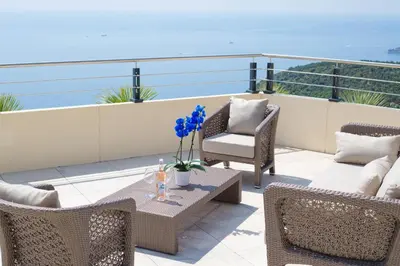 a patio with chairs and a table on a balcony at Les Terrasses d'Eze - Hôtel & Spa in Èze