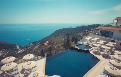 an aerial view of a resort with a swimming pool and umbrellas at Les Terrasses d'Eze - Hôtel & Spa in Èze
