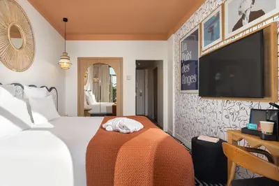 a hotel room with a bed and a flat screen tv at Albert 1er in Nice