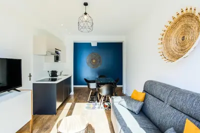 a living room with a couch and a kitchen at Rossini Centre Ville - Proche Tram in Nice