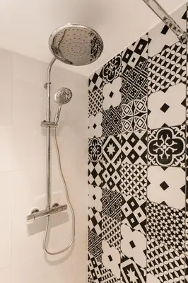 a shower in a bathroom with black and white tiles at Rossini Centre Ville - Proche Tram in Nice