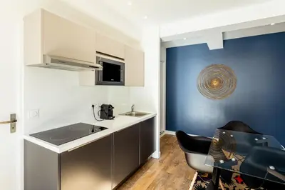 a small kitchen with a sink and a chair at Rossini Centre Ville - Proche Tram in Nice