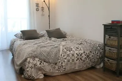 a bed with a black and white blanket and a night stand at Studio Le Fabrina Riviera in Nice