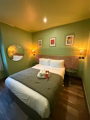 a bedroom with a large bed with two towels on it at Hotel de Berne in Nice