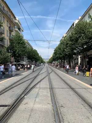 a street with tram tracks in the middle of a city at Hotel de Berne in Nice