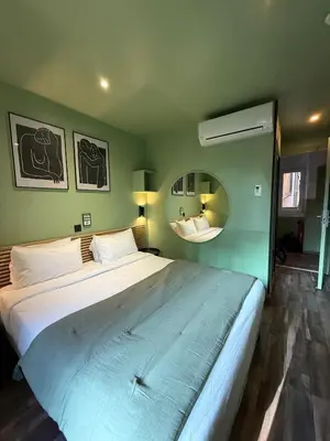 a bedroom with a large bed in a green wall at Hotel de Berne in Nice