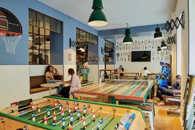 a group of people sitting around a ping pong table at Hostel Ozz Nice in Nice