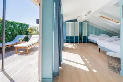 a balcony with white furniture and a blue wall at Hostel Ozz Nice in Nice