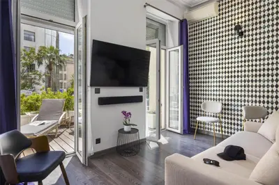 a living room with a couch and a tv at Best Western Plus Hôtel Brice Garden Nice in Nice