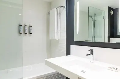 a white bathroom with a sink and a shower at AC Hotel by Marriott Nice in Nice